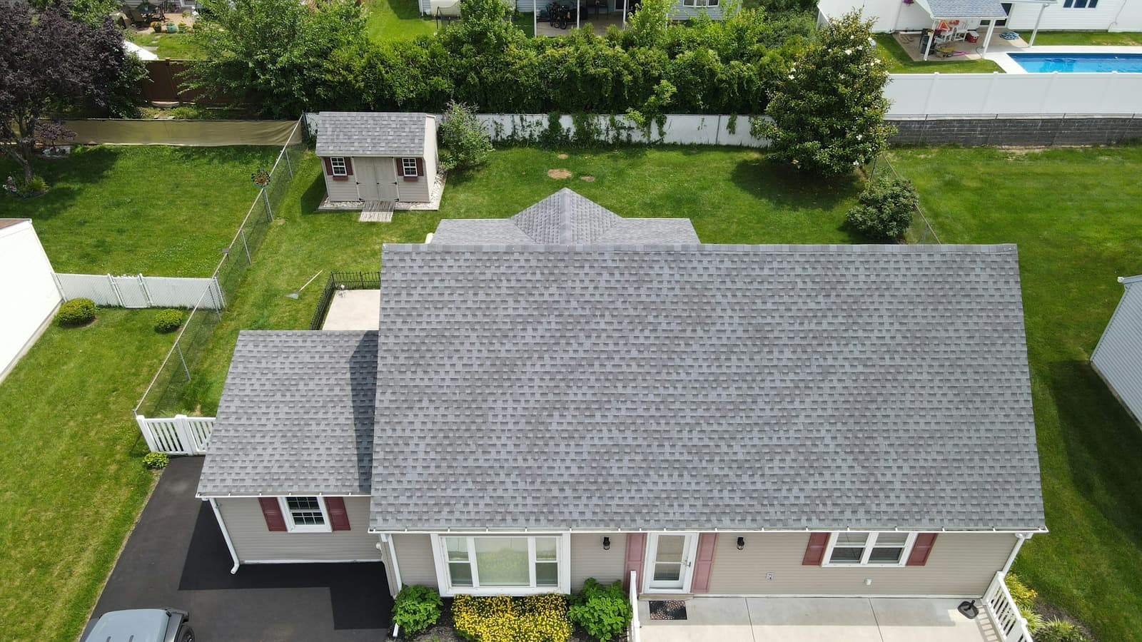 Aerial view of a suburban house with a new gray asphalt shingle roof